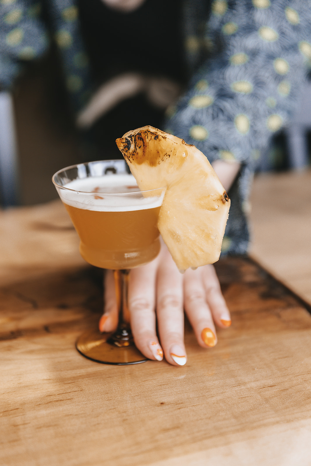 pineapple cocktail with hand around glass